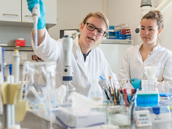 Zwei Personen bei der gemeinsamen Arbeit im Labor.